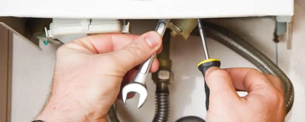Boiler repair technician tightening pipe fittings and connections in Philadelphia, PA