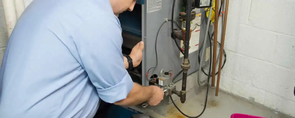 Furnace repair technician inspecting and servicing a home heating system in Philadelphia, PA