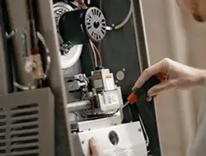 Furnace repair technician inspecting internal components and wiring in Philadelphia, PA