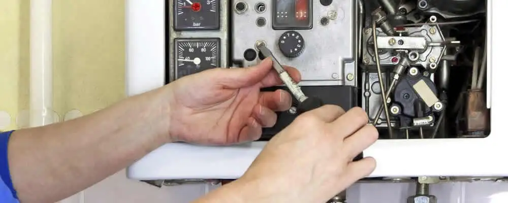 Heating repair technician adjusting boiler controls and components in Philadelphia, PA