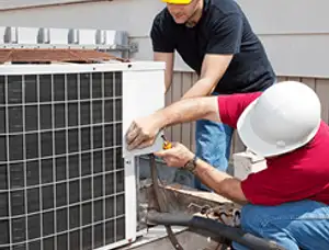 HVAC technicians repairing an outdoor AC unit on a rooftop in Philadelphia, PA