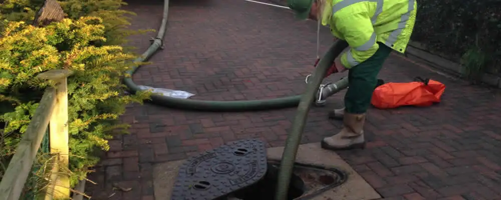 Septic tank cleaning technician servicing a septic tank with a vacuum hose in Philadelphia, PA
