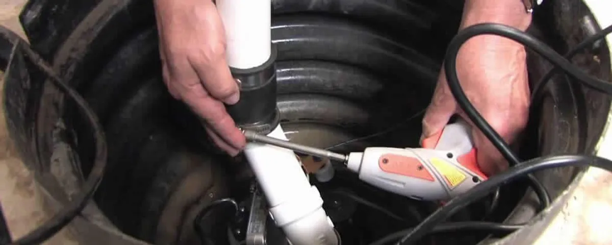 Sump pump installation technician connecting PVC discharge piping in Philadelphia, PA