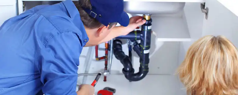 Plumber repairing under-sink drain pipes and fittings in Philadelphia, PA